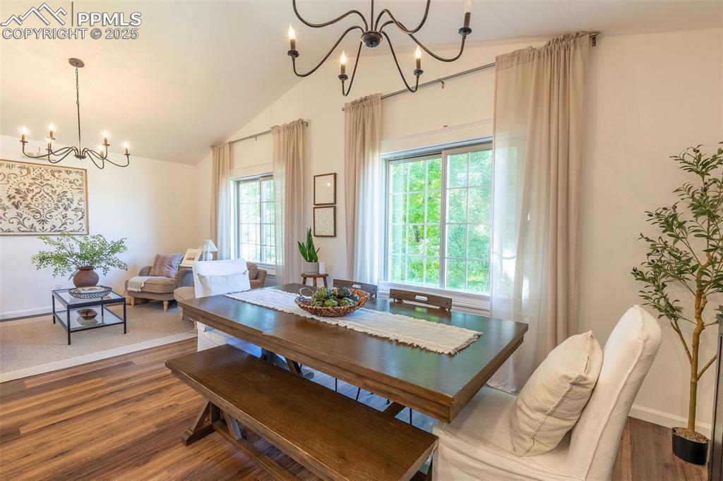 Image 11 of 41: Dining area featuring a chandelier, wood finished floors, and vaulted ceili