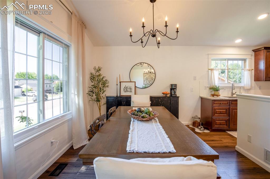 Image 12 of 41: Dining area featuring dark wood-style floors, a chandelier, and recessed li
