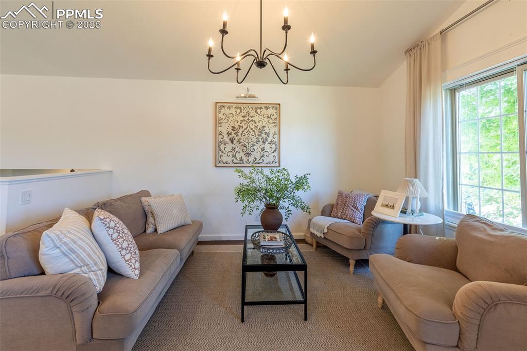 Image 15 of 41: Living room with a chandelier and baseboards