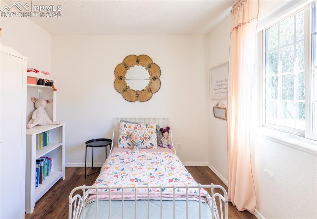 Image 18 of 41: Bedroom featuring dark wood-style flooring and baseboards