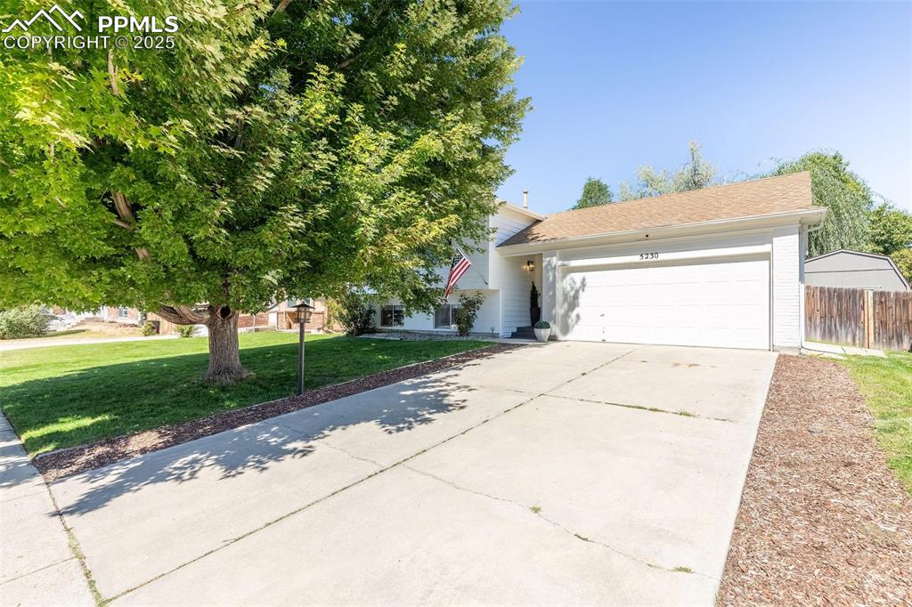 Image 2 of 41: Obstructed view of property with driveway, a garage, and a shingled roof