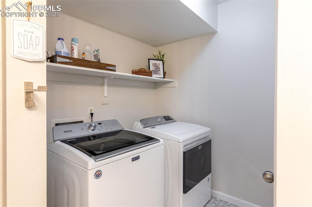Image 28 of 41: Laundry room with washing machine and dryer and baseboards
