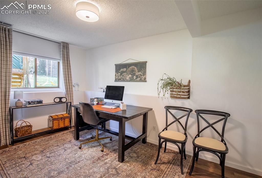 Image 30 of 41: Office featuring a textured ceiling and wood finished floors