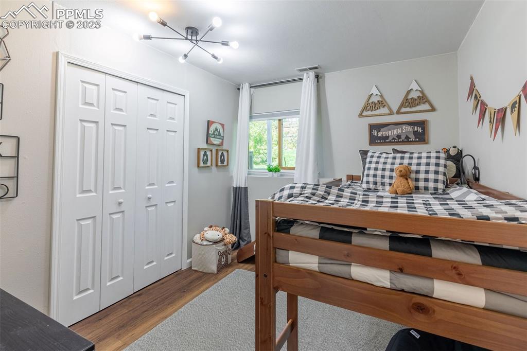 Image 33 of 41: Bedroom featuring dark wood-style flooring, a closet, and a chandelier