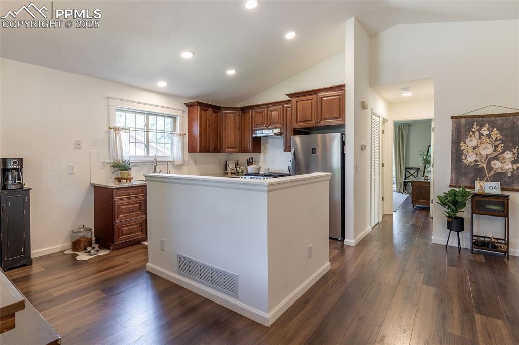Image 6 of 41: Kitchen with light countertops, freestanding refrigerator, dark wood-type f