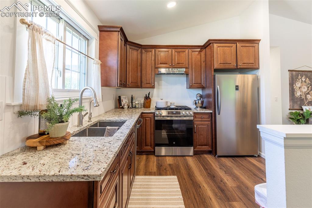 Image 7 of 41: Kitchen featuring appliances with stainless steel finishes, dark wood-style