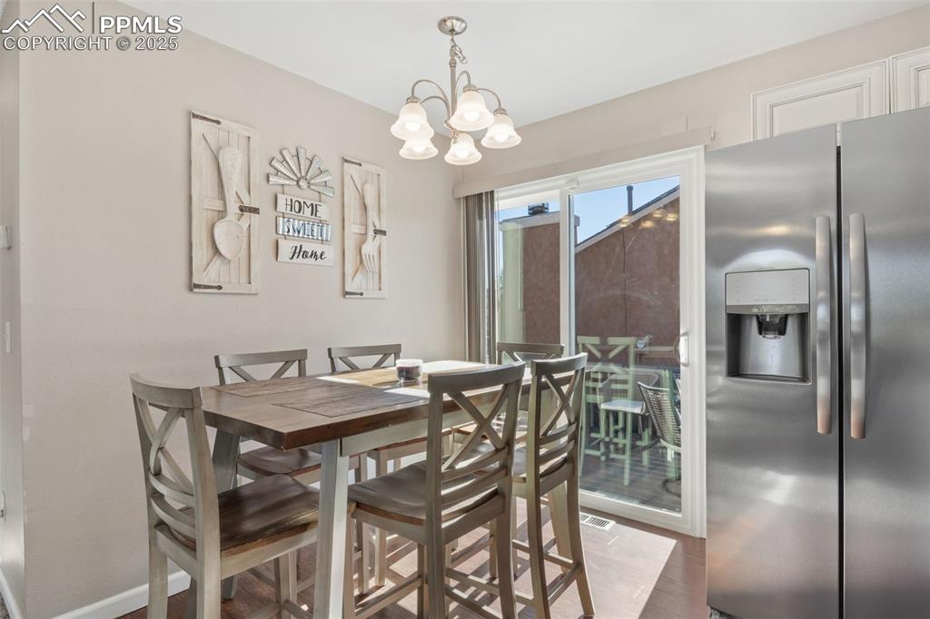 Image 11 of 38: Dining area with light wood-style flooring and a chandelier