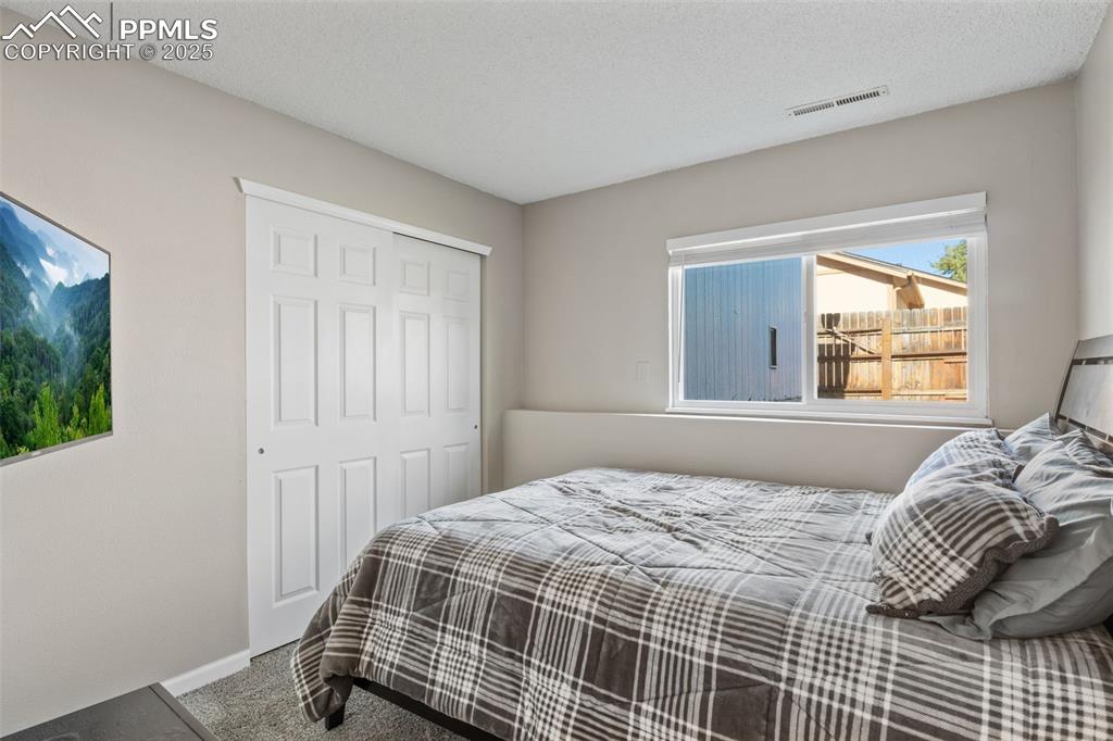 Image 23 of 38: Carpeted bedroom featuring a textured ceiling and a closet