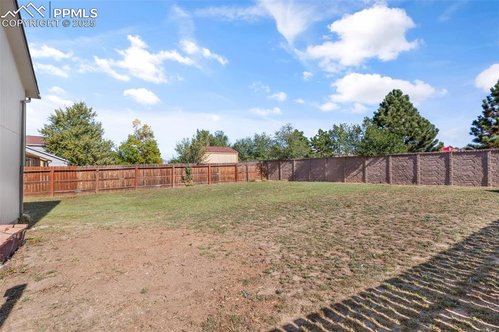 Image 30 of 38: View of fenced backyard