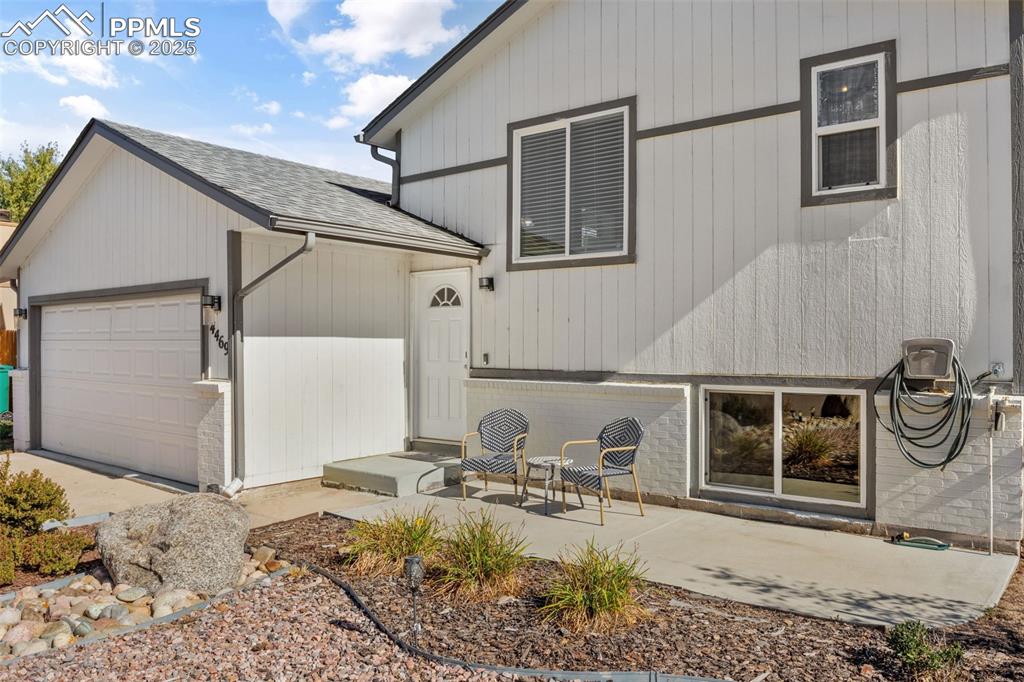 Image 4 of 38: Rear view of property with a shingled roof and an attached garage