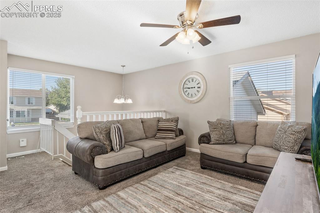Image 7 of 38: Living room with carpet floors, plenty of natural light, a chandelier, and