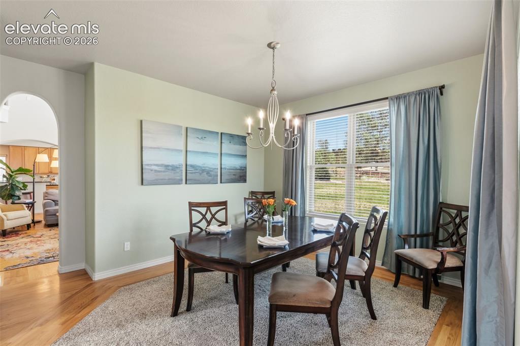 Image 11 of 47: Dining area featuring wood-finish flooring and a central chandelier