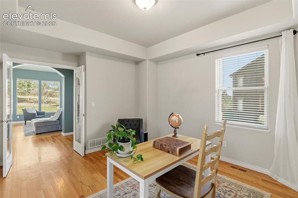 Image 12 of 47: Room with wood-finish flooring, white walls, glass french doors and a reces