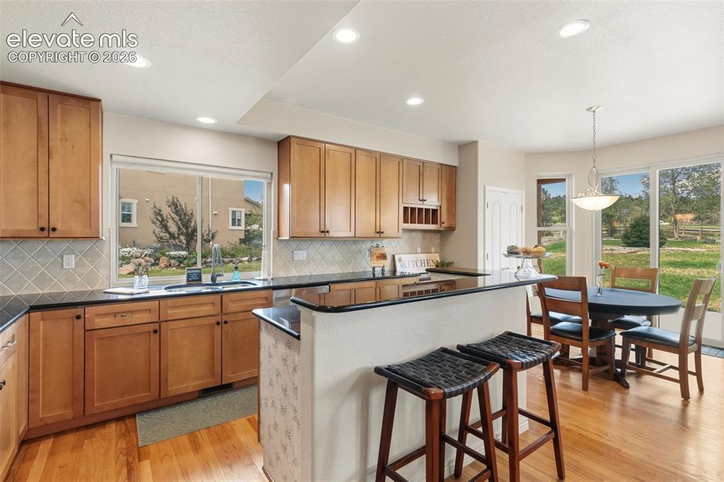 Image 13 of 47: Open-concept kitchen featuring wood-finish flooring, granite counter, desk 