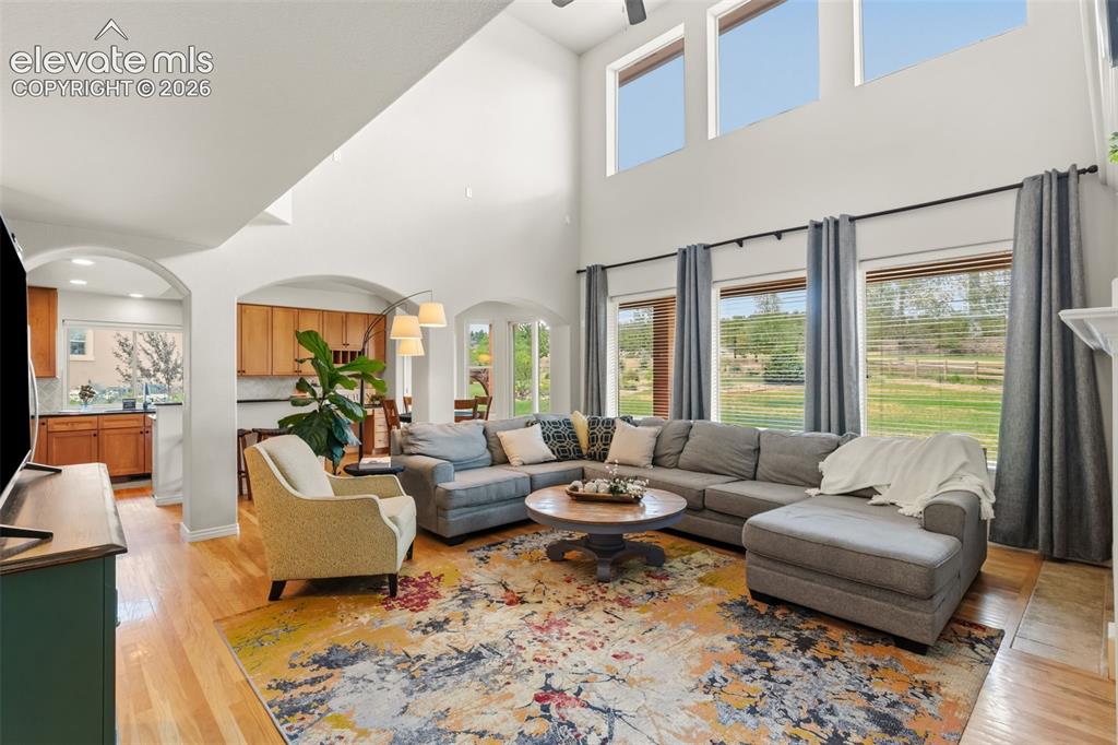 Image 16 of 47: Spacious living area featuring high vaulted ceilings, multiple arched doorw