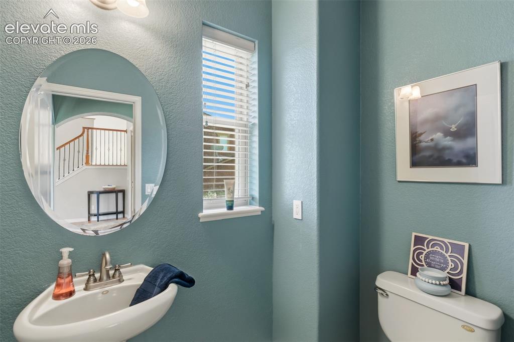 Image 18 of 47: Pedestal sink with a polished chrome faucet, an oval frameless mirror, and 