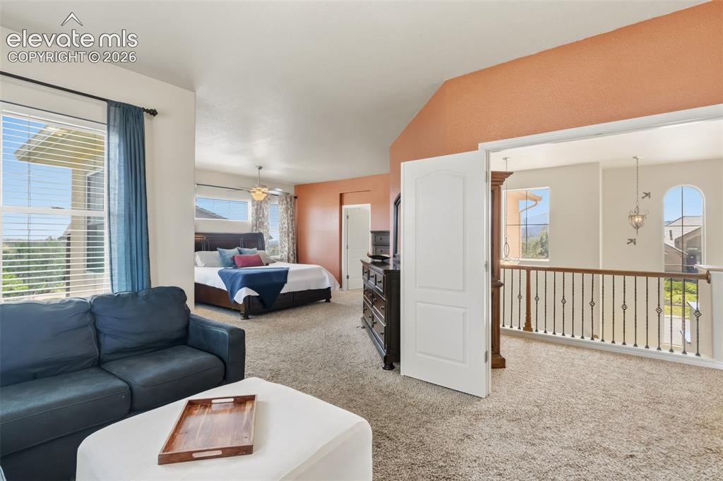 Image 23 of 47: Carpeted bedroom space featuring a vaulted ceiling with an accent wall and 