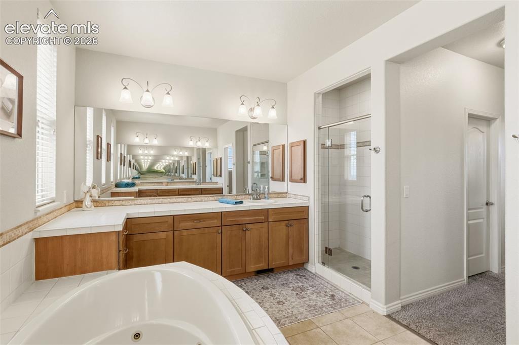 Image 26 of 47: Bathroom featuring a dual vanity with wood cabinetry and a light-colored co