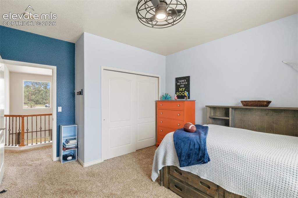 Image 28 of 47: Carpeted bedroom featuring a built-in closet with bi-fold doors, a ceiling 