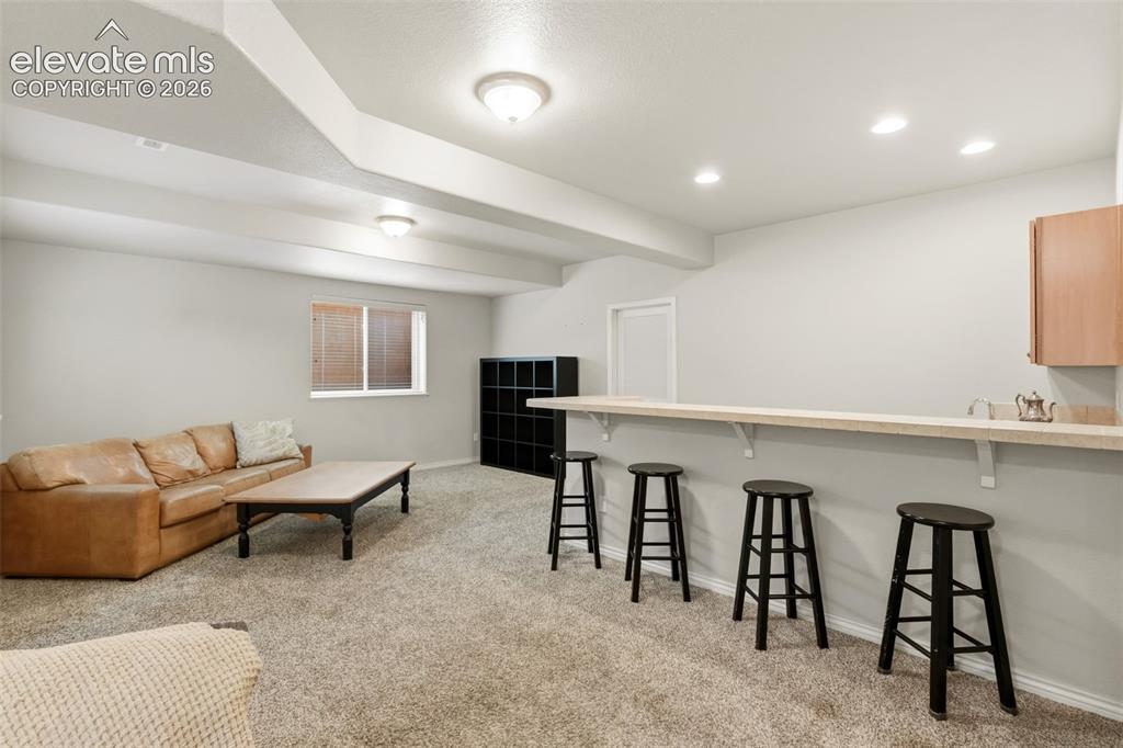 Image 34 of 47: Spacious recreational area featuring recessed lighting, a built-in bar, and