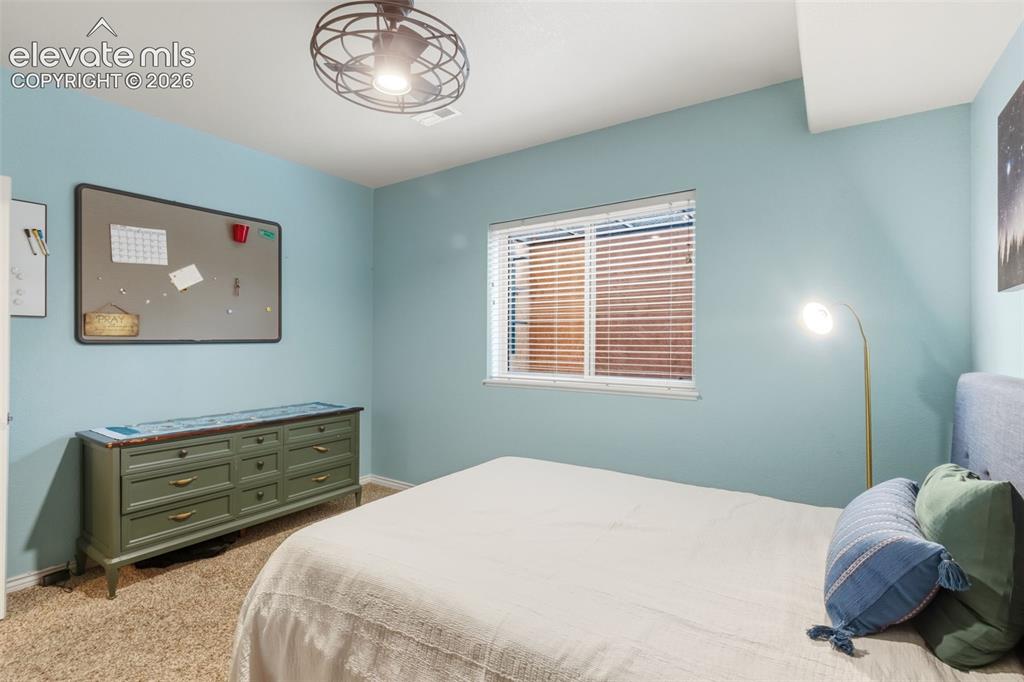 Image 36 of 47: Carpeted room with light blue walls and a window featuring blinds