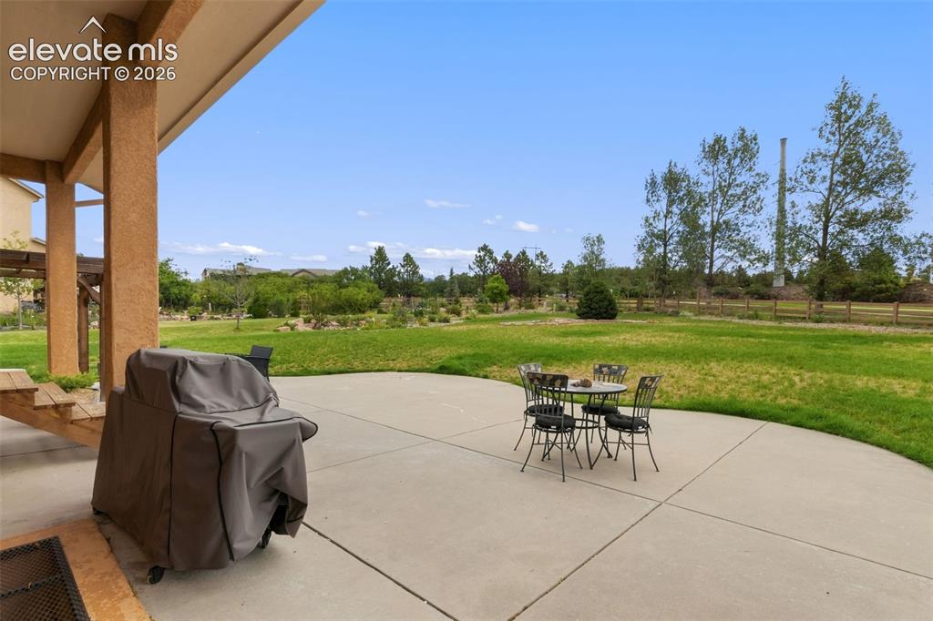 Image 40 of 47: Expansive concrete patio with a covered area extending from the home