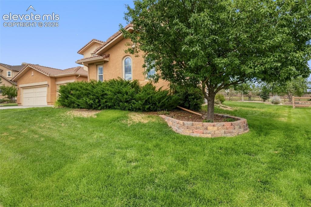 Image 7 of 47: Tuscan-style exterior with a tile roof and arched windows