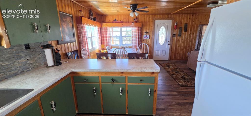 Image 15 of 35: Kitchen featuring green cabinetry, light-toned countertops, a stainless ste
