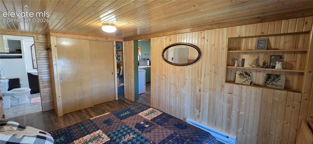 Image 18 of 35: Wood paneling throughout, built-in shelving, wood-finish flooring, recessed