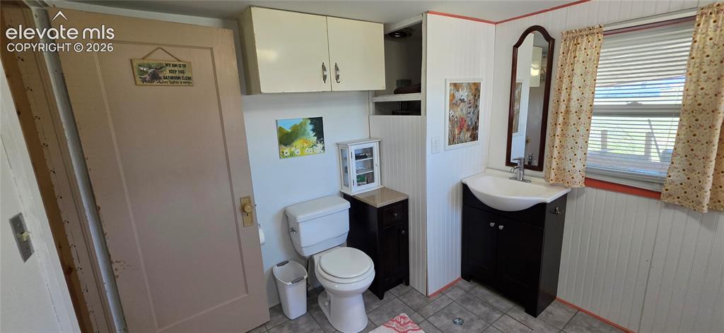 Image 20 of 35: White beadboard walls, dark wood-finish vanity with an integrated basin sin
