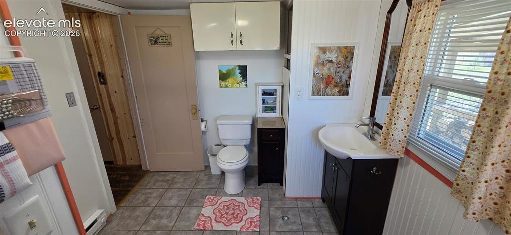 Image 21 of 35: Bathroom featuring tile flooring, a white vanity with an integrated sink, a