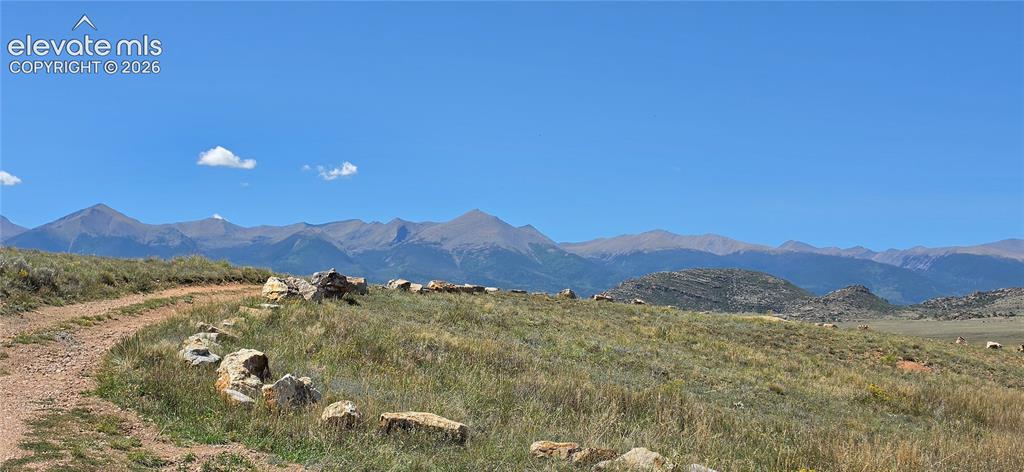 Image 33 of 35: Mountain range backdrop, open terrain, natural rock formations, and clear s