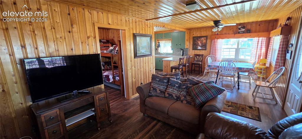 Image 4 of 35: Wood-paneled walls and ceiling, wood-finish flooring, recessed lighting, an