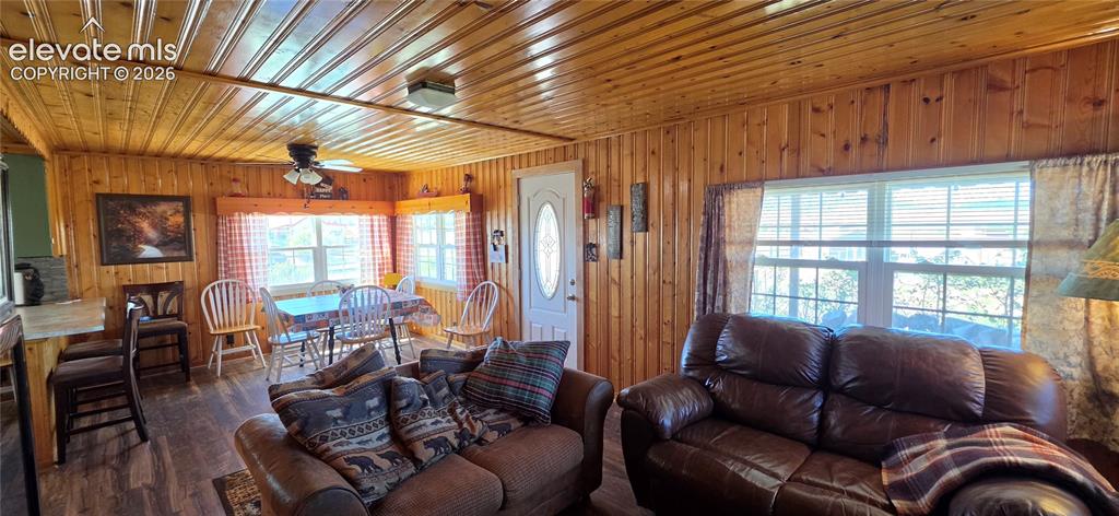 Image 5 of 35: Wood-paneled walls and ceiling, wood-finish flooring, multiple windows, and