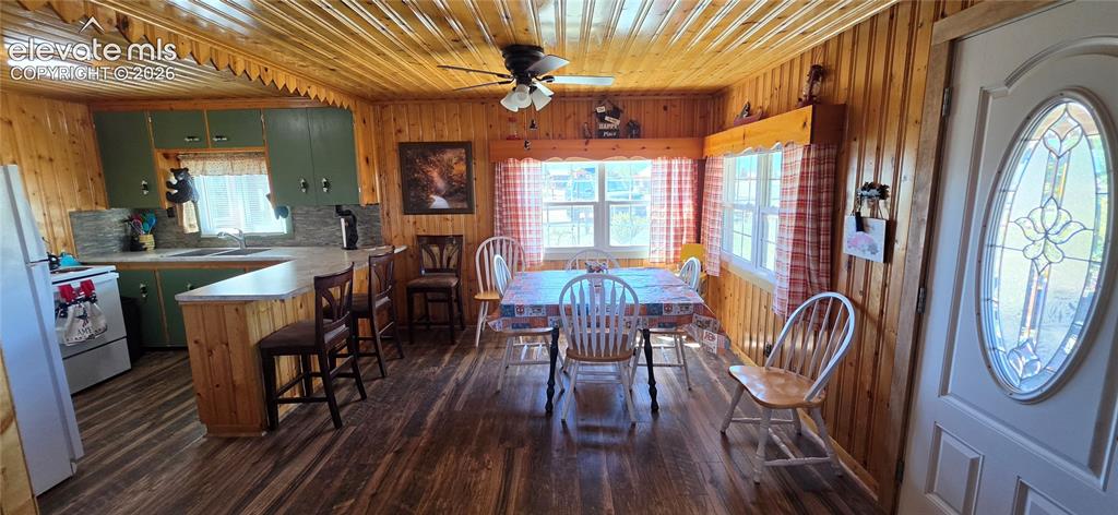 Image 7 of 35: Wood-finish flooring throughout, wood-paneled walls and ceiling, kitchen wi