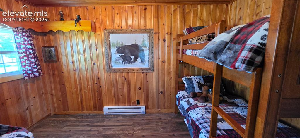Image 8 of 35: Wood-paneled walls, wood-finish flooring, built-in bunk beds, and a window 