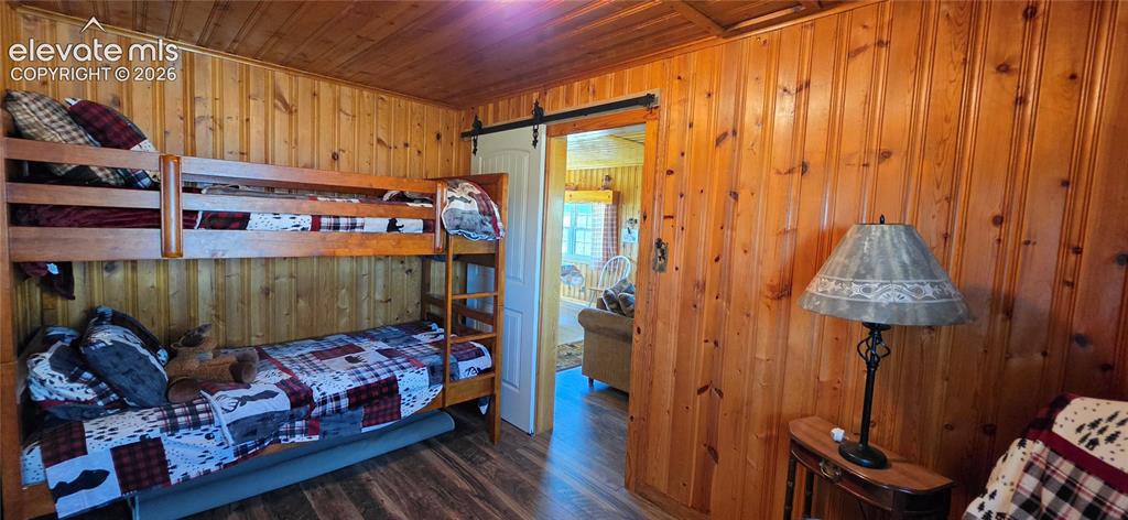 Image 9 of 35: Wood-finish flooring, vertical wood plank wall and ceiling finishes, and a