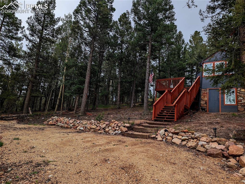 Caption: Forest-surrounded dwelling featuring natural stone cladding and grey siding