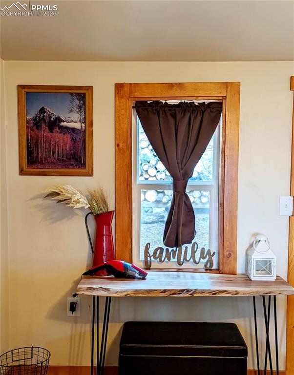 Image 14 of 21: Window with natural wood trim and a dark brown curtain