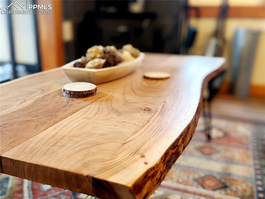 Image 16 of 21: Live-edge wood table featuring a natural grain finish and irregular edge