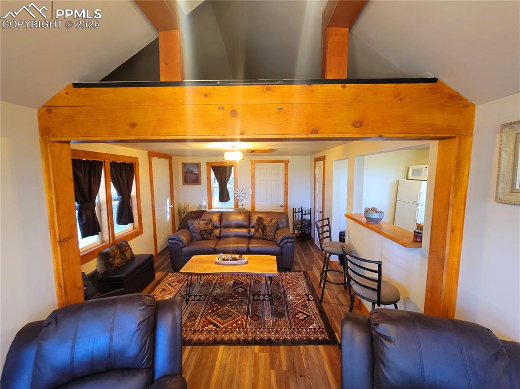 Image 17 of 21: Open-concept living area featuring rich wood-finish flooring, a prominent w