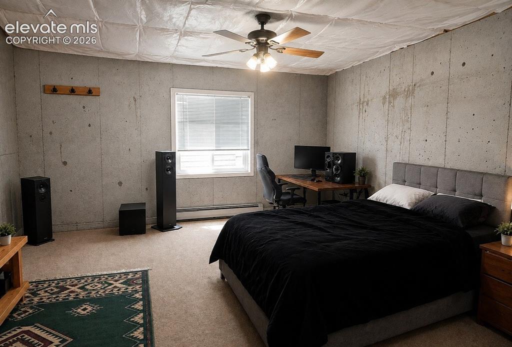 Image 19 of 20: Spacious room featuring concrete walls, a single window with blinds, and ca