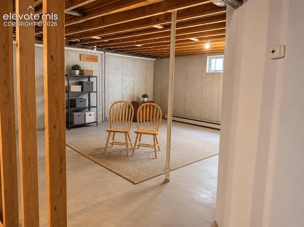 Image 20 of 20: Unfinished basement with visible wood ceiling joists and concrete walls