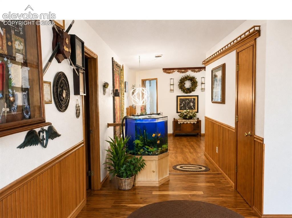 Image 9 of 20: Hallway featuring wood-finish flooring, wainscoting, and a built-in cabinet