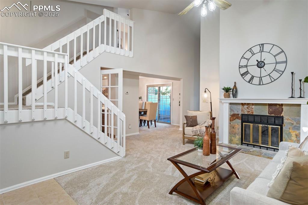 Image 3 of 50: Soaring ceilings, slate-accented fireplace, and dramatic staircase created 