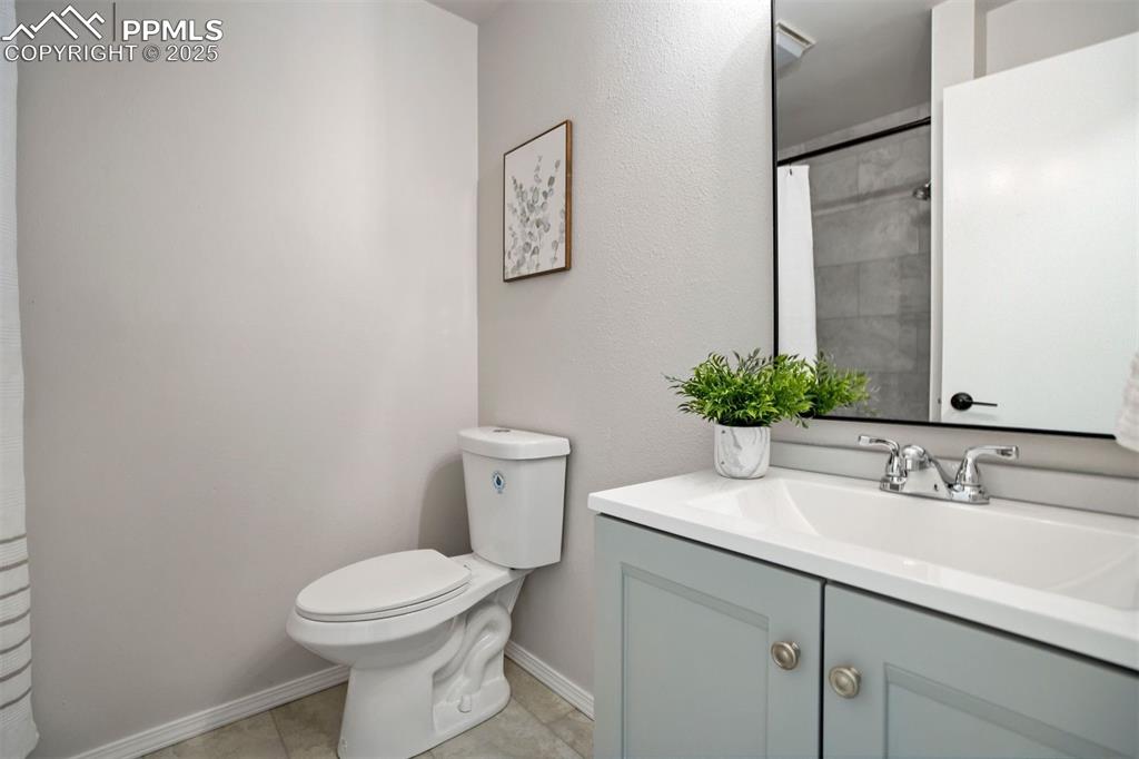 Image 31 of 50: Newly refinished basement bathroom has a shower, new vanity, toilet, and ti