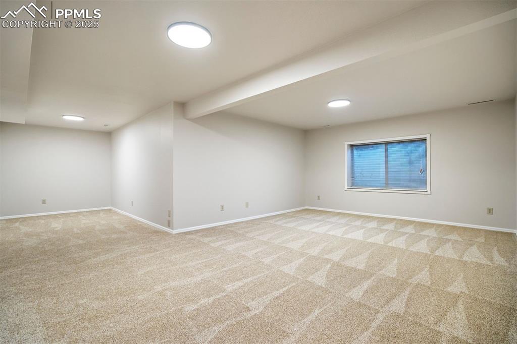 Image 36 of 50: Basement family room is L-shaped and provides expansive opportunities for r