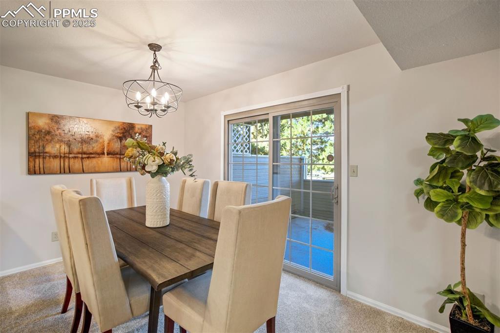 Image 5 of 50: Elegant dining space with updated lighting and seamless walkout to the fenc
