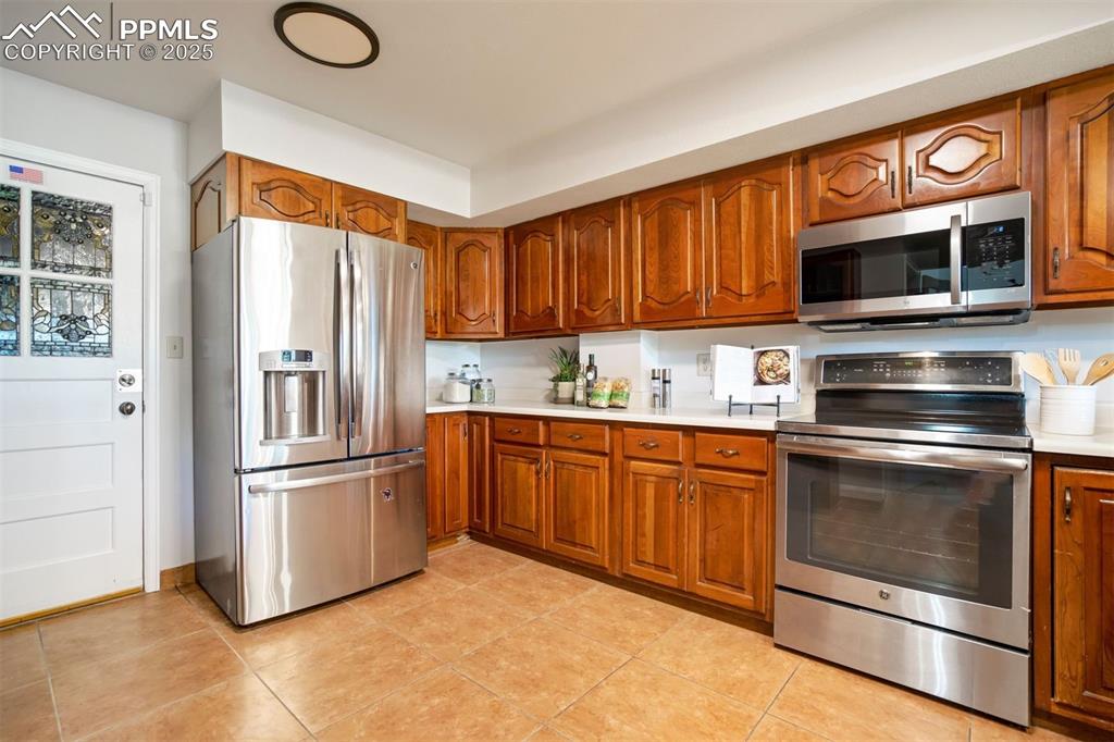 Image 6 of 50: Ample workspace for the chef, featuring stainless steel appliances, warm wo