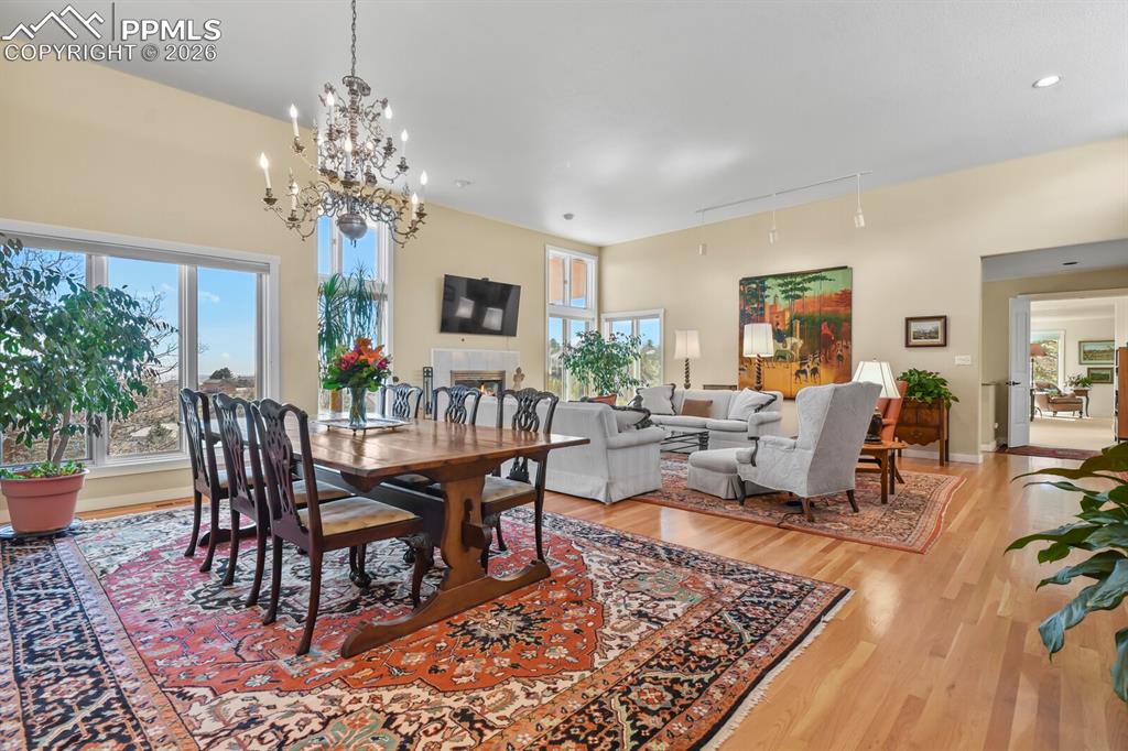 Image 13 of 50: Dining Area showing all the windows, chandelier and hardwood floors.  